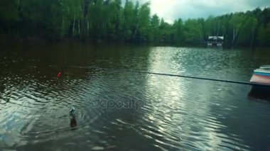Küçük bir çocuk ve dedesi büyük somon sırasında tatlısu balıkçılık gölde yakalamak.