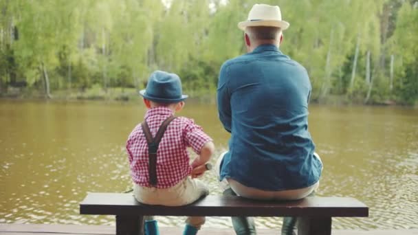 Gradfather en zijn kleinzoon zijn gieten lijnen tijdens de zalmvisserij in de rivier — Stockvideo