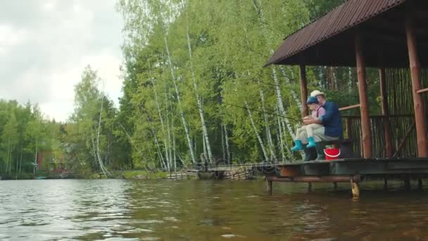 Красавчик и его дедушка рыбачат на озере. — стоковое видео