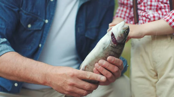 Menino e seu avô com salmão capturado em mãos na pesca no lago — Fotografia de Stock