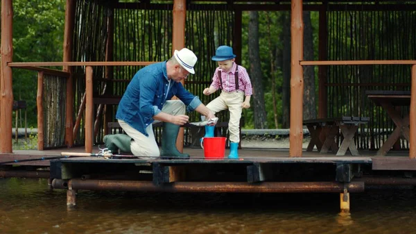 Niño y su abuelo la captura de salmón en la pesca de agua dulce en el lago — Foto de Stock