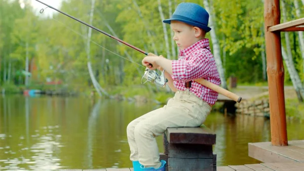 Kleiner Junge mit Strohhut beim Süßwasserangeln am See — Stockfoto