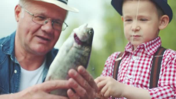 Familjeporträtt av liten pojke och hans morfar på sötvattensfiske — Stockvideo