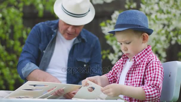 Granddad is playing with his grandson in the backyard — Stock Video