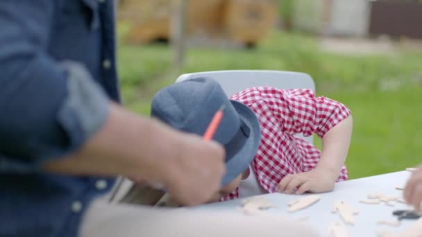 Niño vistiendo es viendo a su padre follando un avión de madera — Vídeo de stock