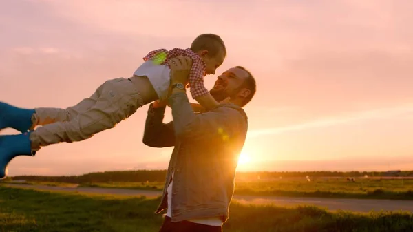 Malý chlapec a jeho otec hraje při západu slunce — Stock fotografie