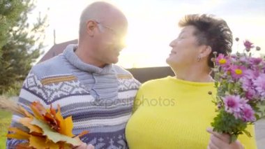 couple de personnes âgées s'embrasser au coucher du soleil