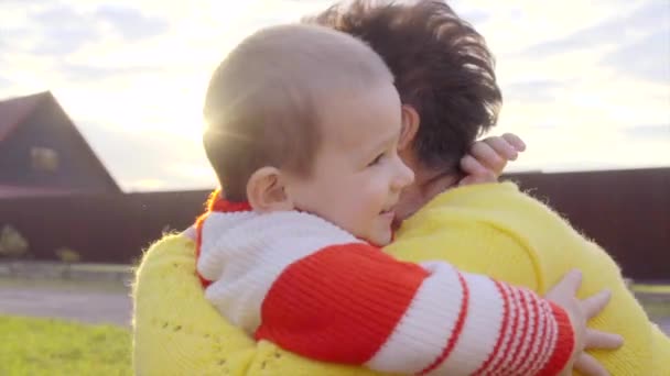 Küçük bir çocuk ve onun büyükanne açık gün batımında — Stok video