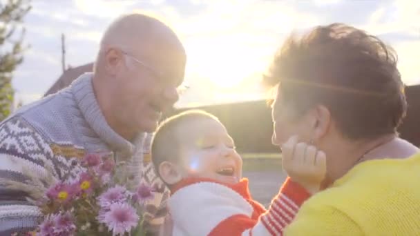 Jongetje is genieten van de ontmoeting met oma en opa bij zonsondergang — Stockvideo