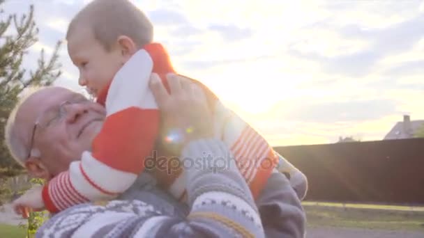 Malý chlapec se svým dědečkem při západu slunce — Stock video