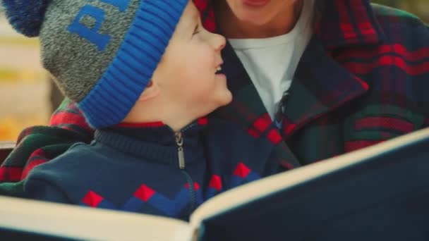 Acercamiento retratos de madre y niño pequeño libro de razonamiento en el bosque de otoño — Vídeo de stock