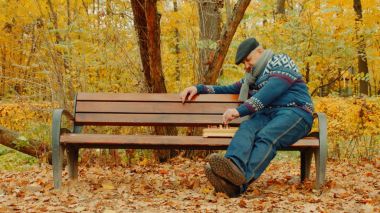 Yaşlı adam satranç yalnız sonbahar parkta bankta oynuyor