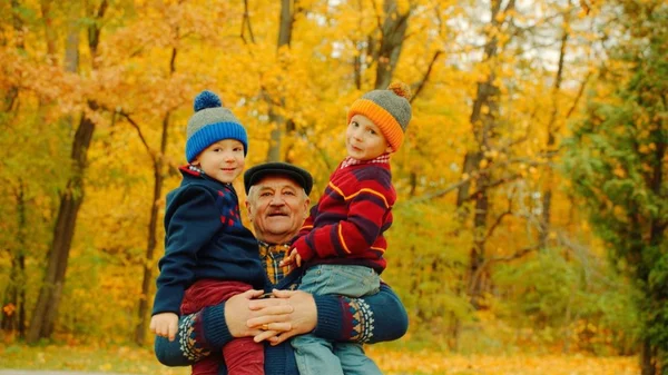 Zwei kleine Jungen und ihr Großvater im Herbstpark — Stockfoto