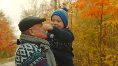 Mutlu küçük çocuk sonbahar parkta dedesi sarılma