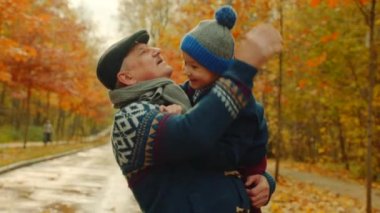 Küçük bir çocuk ve onun dedesi sonbahar parkta