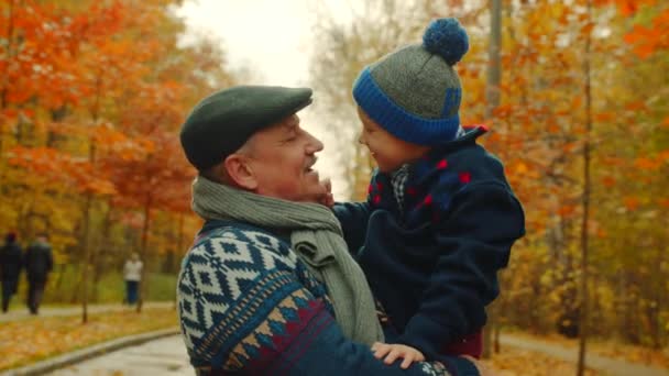 Niño y su abuelo en el parque de otoño — Vídeo de stock