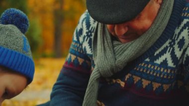 Dedesi sonbahar parkta satranç oynamak için onun torunları öğretiyor