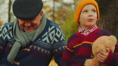 Dedesi sonbahar parkta satranç oynamak için onun torunları öğretiyor