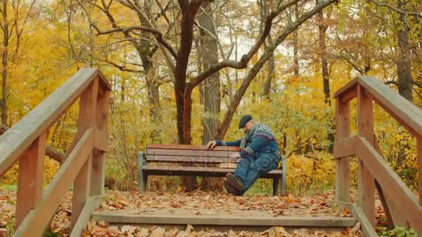 Alter mann spielt schach allein auf der bank im herbstpark — Stockvideo