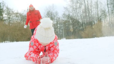 Küçük bir çocuk ve onun dedesi kış parkta oynuyorlar