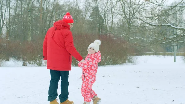 Niño pequeño está dando un paseo con su abuelo en el parque de invierno —  Fotos de Stock