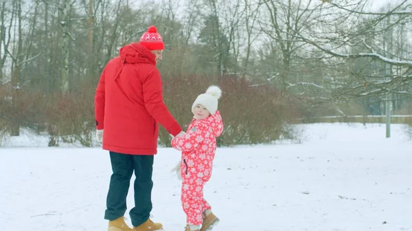 Niño pequeño está dando un paseo con su abuelo en el parque de invierno —  Fotos de Stock