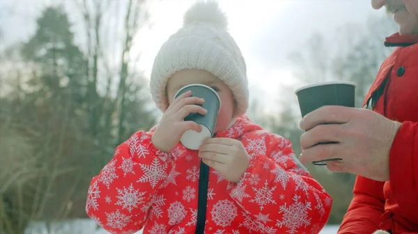 Kleiner Junge und sein Großvater trinken heißen Tee im Winterpark — Stockfoto