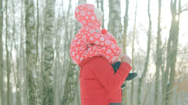 El niño está sentado sobre los hombros de su abuelo mientras camina en el parque de invierno. —  Fotos de Stock