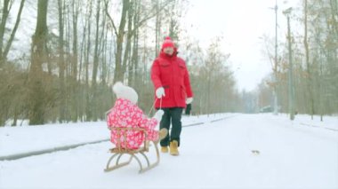 Büyükbabası ile kış parkta kızak üzerinde mutlu küçük çocuk