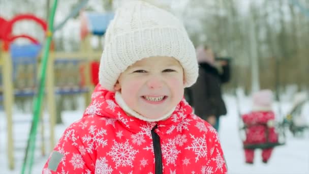 Счастливый мальчик на детской площадке зимой — стоковое видео