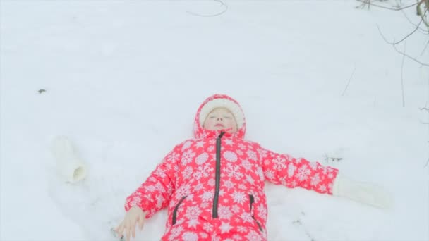 Jongetje is het maken van een engel in de sneeuw — Stockvideo