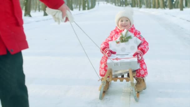 Liten pojke med julklappar i hans släde — Stockvideo