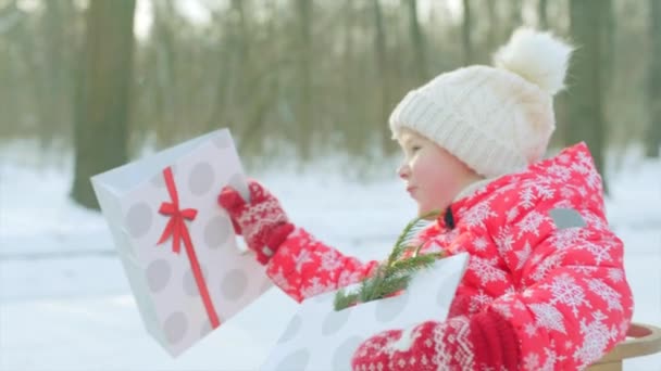 Kleiner Junge mit Weihnachtsgeschenken im Schlitten — Stockvideo