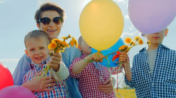 3 つの男の子とそのお母さん色風船や花を浮かべて — ストック写真