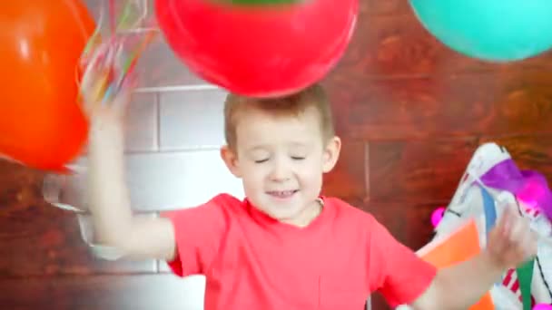 Menino está brincando com balões coloridos na sala de jogos — Vídeo de Stock