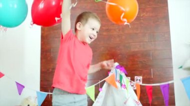 Küçük çocuk oyun odası renkli balonlar ile oynuyor