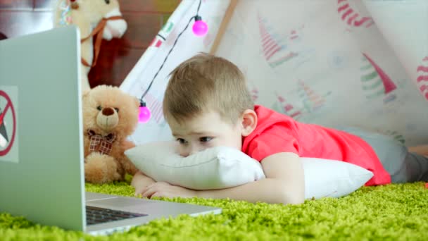 Niño pequeño está viendo dibujos animados en la sala de juegos — Vídeos de Stock