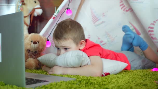 Menino está assistindo desenhos animados na sala de jogos — Vídeo de Stock