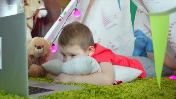 Niño pequeño está viendo dibujos animados en la sala de juegos — Vídeos de Stock