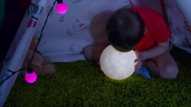Kendini onun elinde oyuncak moon ile küçük çocuk Kızılderili çadırı odasında yaptı.