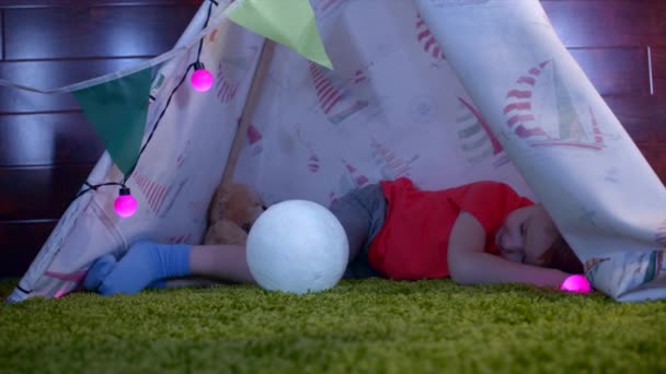 Menino está dormindo no wigwam self-made na sala de jogos — Vídeo de Stock