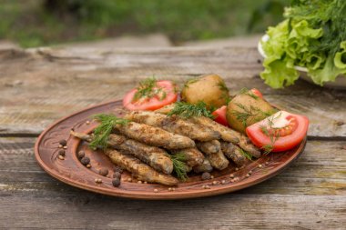 Ahşap rustik masa üzerinde kızarmış küçük balık