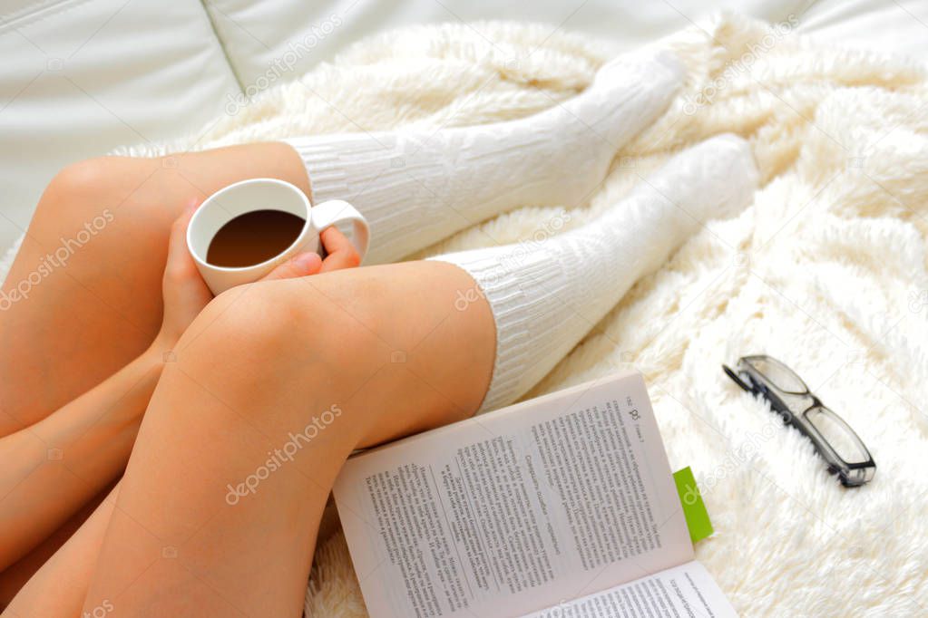Legs of a young girl drinking coffee