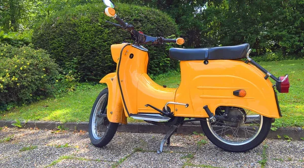 Eski bir sarı motorlu scooter.