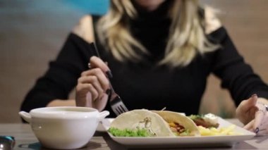 Güzel bir kız restoranda yemek yer.