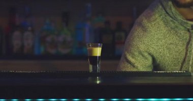 Barmen bar tezgahında kokteyl hazırlıyor..