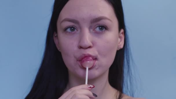 一个年轻姑娘在吸棒棒糖 — 图库视频影像
