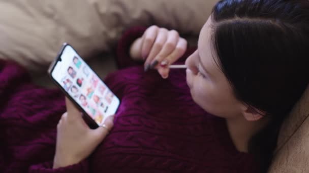 Een Jong Meisje Zuigen Een Lolly Zoek Smartphone — Stockvideo