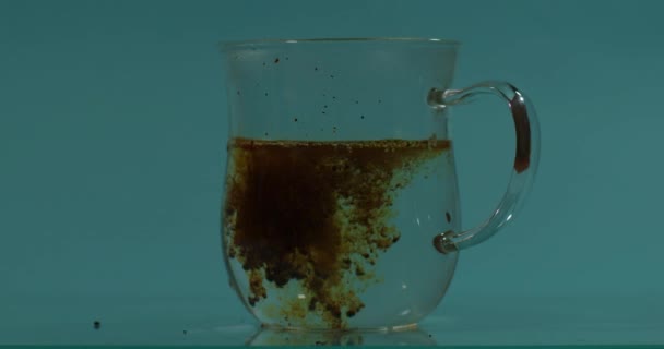 Koffie lost op in water blauwe achtergrond — Stockvideo