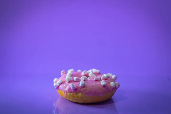 Плоский лежал розовый пончик украшен брызгами на голубом фоне — стоковое фото